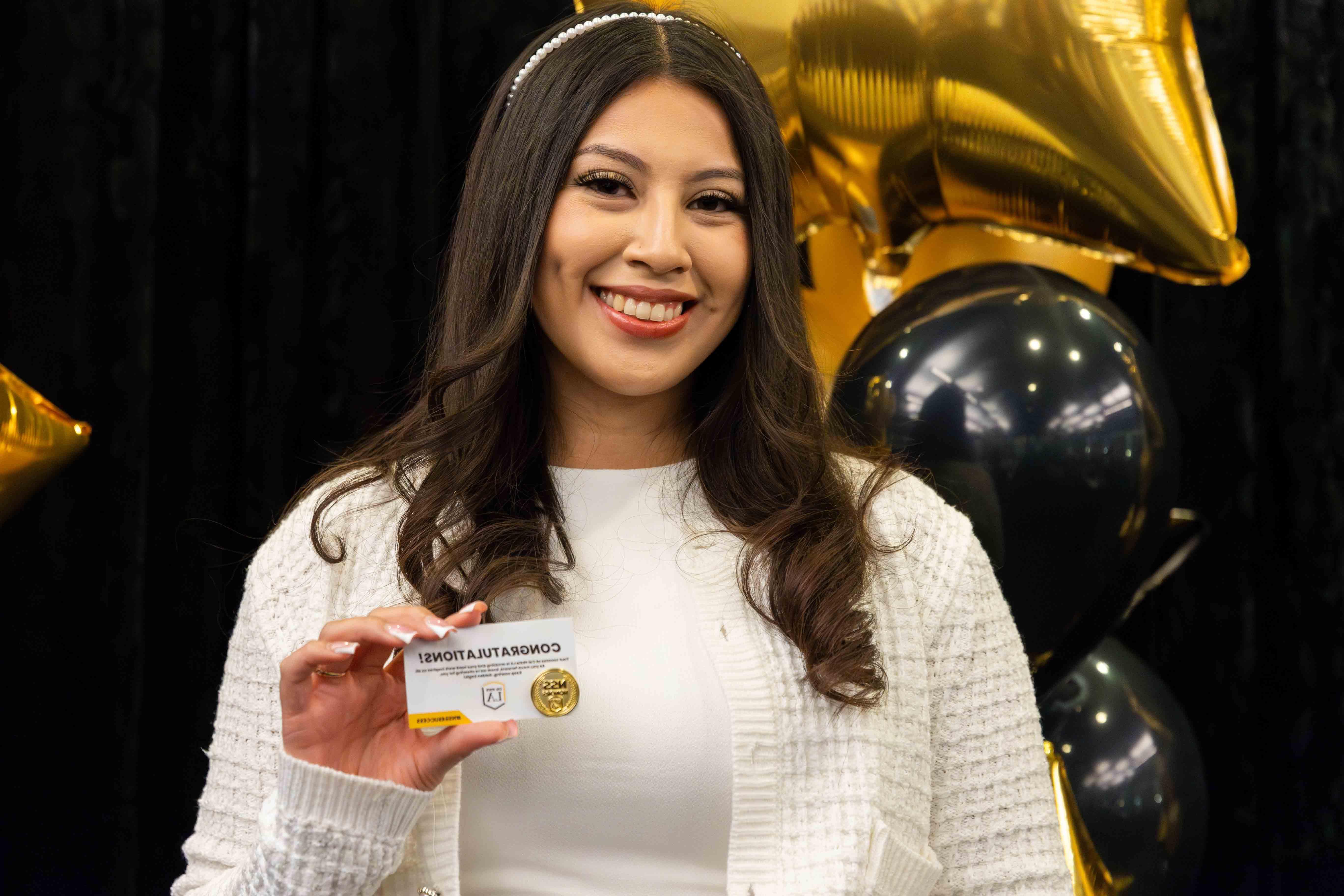 Cal State LA student holding up NSS Honors Pin