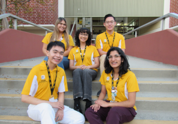 五名学生同伴健康教育者坐在学生健康中心的台阶上